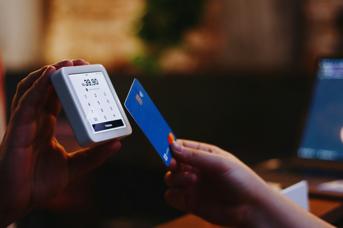 A person holding a card in one hand and a phone in the other.