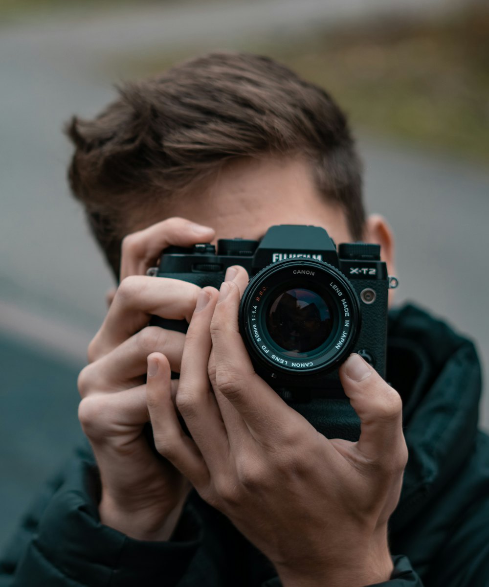 A photographer raising a camera to his eye to take a shot