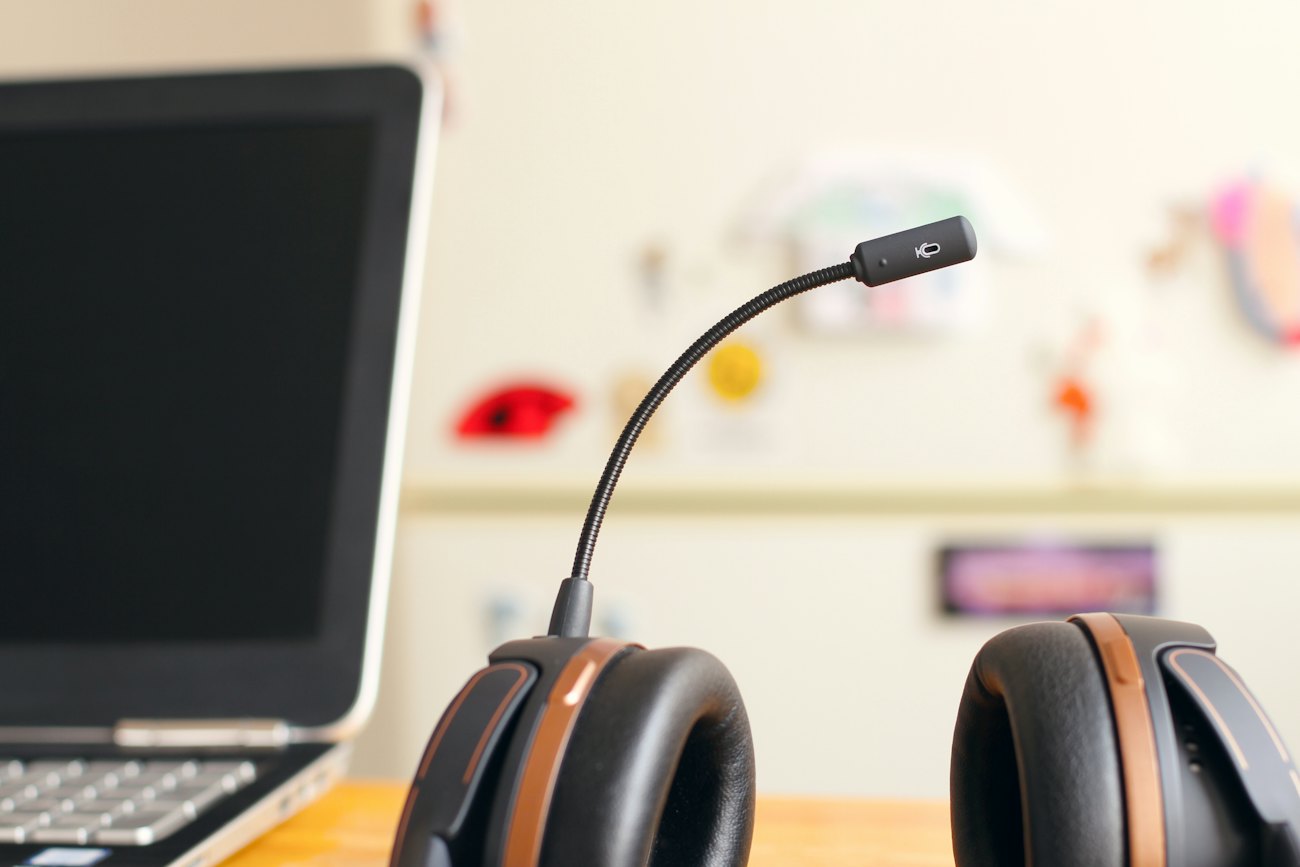 A support agent at a desk with a headset, working on a laptop